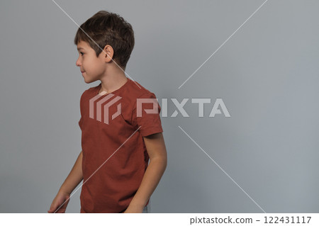 Boy in casual attire impersonates a wild creature, eyes popped and roaring. Reminds viewers of the uninhibited spirit of childhood and the universality of Youngster dramatizes a scare. 122431117