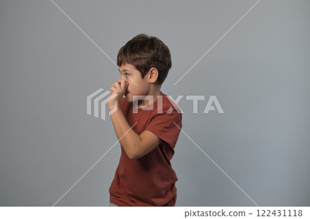 Boy in casual attire impersonates a wild creature, eyes popped and roaring. Reminds viewers of the uninhibited spirit of childhood and the universality of Youngster dramatizes a scare. 122431118