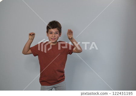 A boy with raised hands shows surprise, a stance of innocence. It reflects the importance of nurturing curiosity in education. 122431195