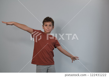 A jovial lean, in simple attire, encapsulates the current move towards capturing the unscripted beauty of childhood in photography. 122431222