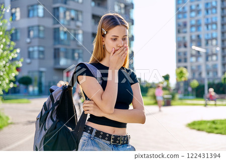 Sad unhappy teenage college student girl with backpack, outdoor, city background Sad unhappy teenage college student girl with backpack, outdoor, city background 122431394