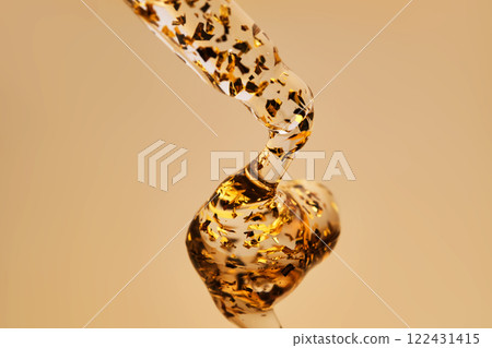 A delicious drop of 24k gold serum on a gold background. 122431415