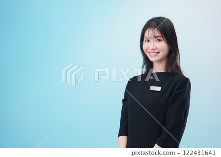 Smiling staff wearing black clothes and name tags (light blue background) Smiling staff wearing black clothes and name tags (light blue background) 122431641