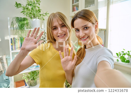 Selfie portrait of two cheerful attractive young teenage females in home interior Selfie portrait of two cheerful attractive young teenage females in home interior 122431678