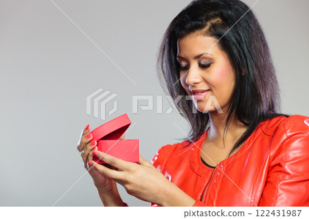 Girl in red holding heart gift 122431987