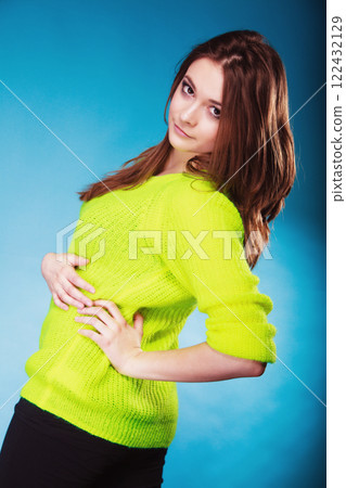 Portrait teen girl in vivid colour sweater on blue Portrait teen girl in vivid colour sweater on blue 122432129