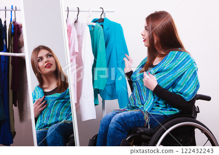 handicapped girl on wheelchair choosing clothes handicapped girl on wheelchair choosing clothes 122432243