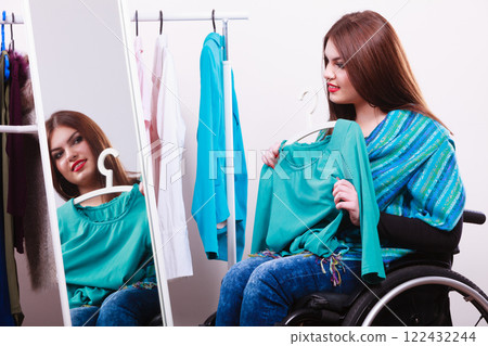 handicapped girl on wheelchair choosing clothes handicapped girl on wheelchair choosing clothes 122432244