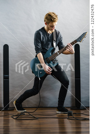 Young man playing electric guitar 122432476