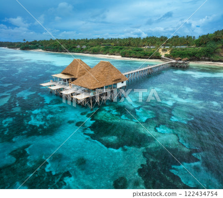 Aerial view of bungalow, jetty, white sandy beach, blue sea Aerial view of bungalow, jetty, white sandy beach, blue sea 122434754