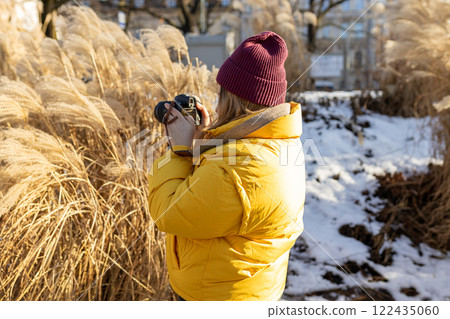 Professional woman photographer taking outdoor portraits with prime lens outdoors. Female taking pictures on vacation. Nature and sunlight. Professional woman photographer taking outdoor portraits with prime lens outdoors. Female taking pictures on vacation. Nature and sunlight. 122435060