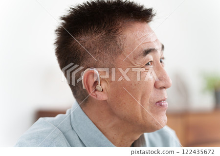 Senior man wearing a hearing aid Senior man wearing a hearing aid 122435672