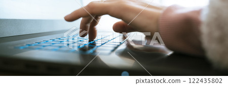 Low angle closeup view of female hand working on laptop computer 122435802