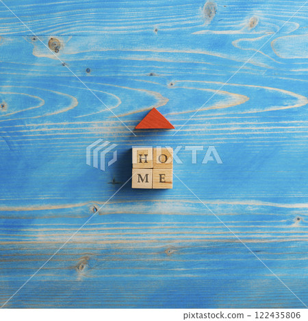 Top view of a house made of wooden blocks with a red roof and a Home sign on it 122435806