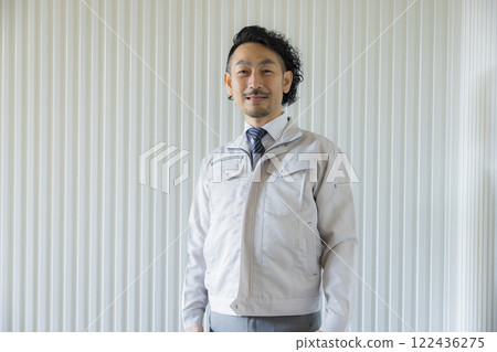 A middle-aged man wearing work clothes thinking A middle-aged man wearing work clothes thinking 122436275