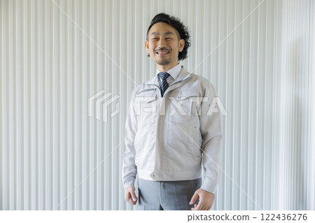 A middle-aged man wearing work clothes thinking A middle-aged man wearing work clothes thinking 122436276