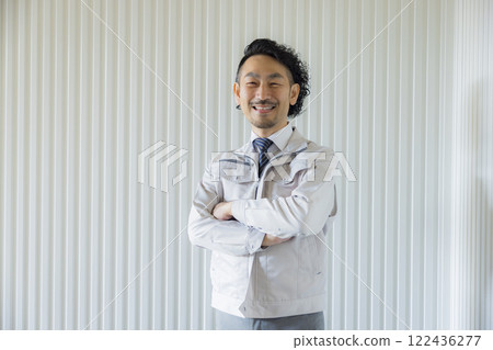 A middle-aged man wearing work clothes thinking 122436277
