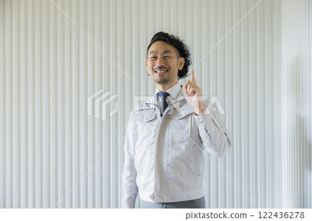 A middle-aged man wearing work clothes thinking A middle-aged man wearing work clothes thinking 122436278