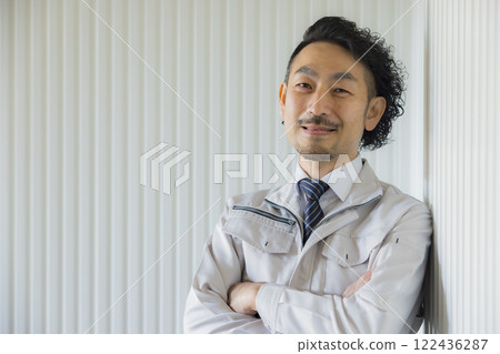 A middle-aged man wearing work clothes thinking A middle-aged man wearing work clothes thinking 122436287