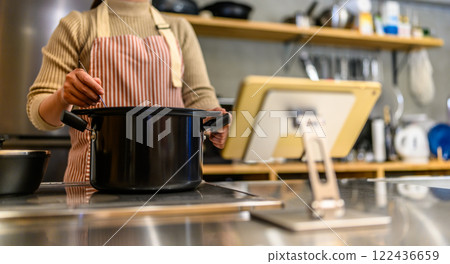 Portrait of a woman cooking 122436659