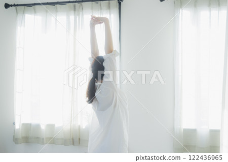 Woman opening curtain 122436965