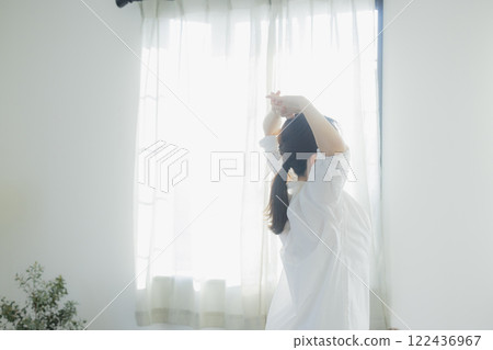 Woman opening curtain 122436967