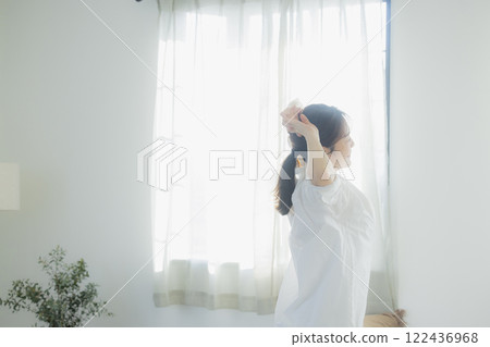 Woman opening curtain 122436968