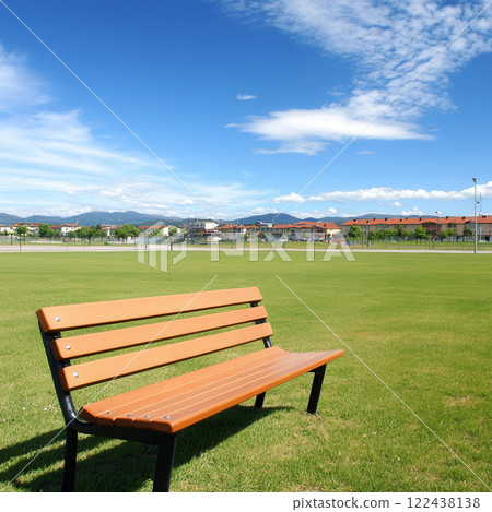 Empty Park Bench Under Clear Blue Sky with Green Grass Landscape Empty Park Bench Under Clear Blue Sky with Green Grass Landscape 122438138