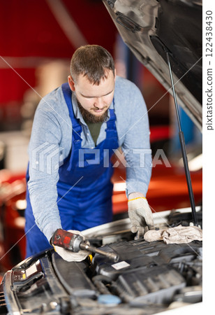 man checks the condition of the engine and oil under the hood 122438430