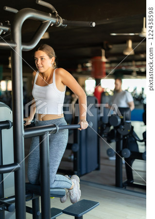 Young woman exercising on gravitron machine Young woman exercising on gravitron machine 122438598