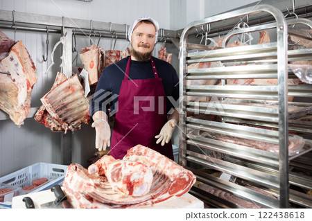 Bearded butchery worker preparing fresh veal cuts for sale Bearded butchery worker preparing fresh veal cuts for sale 122438618