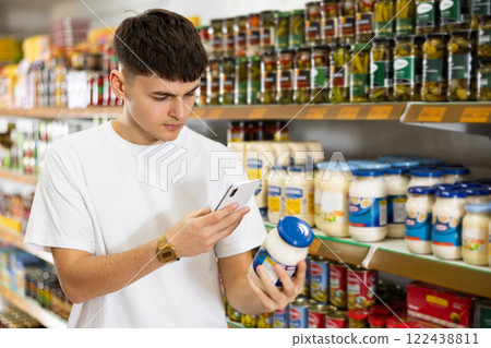Guy scan barcode on mayonnaise jar with phone in supermarket 122438811