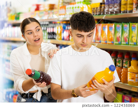 in shop, man and woman chooses drink. in shop, man and woman chooses drink. 122438869