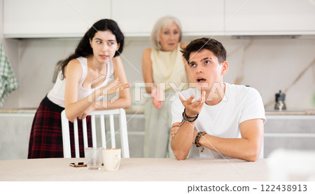 Elderly woman mother and young girl during family quarrel accuse adult son Elderly woman mother and young girl during family quarrel accuse adult son 122438913