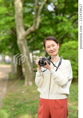 Senior woman holding a camera Senior woman holding a camera 122439627