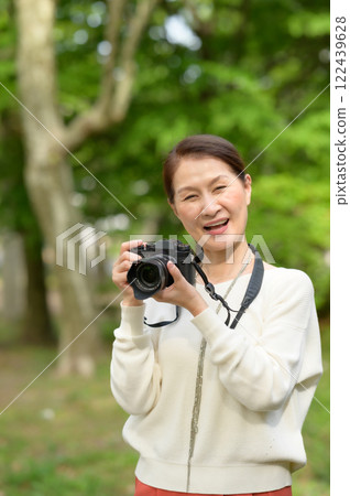 Senior woman holding a camera Senior woman holding a camera 122439628