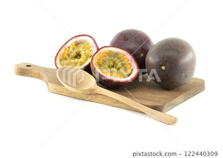 Fresh passion fruits and wooden spoon lying on cutting board Fresh passion fruits and wooden spoon lying on cutting board 122440309