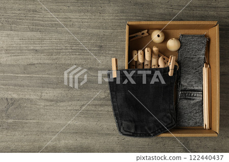 Pieces of denim fabric and box on wooden background, space for text Pieces of denim fabric and box on wooden background, space for text 122440437