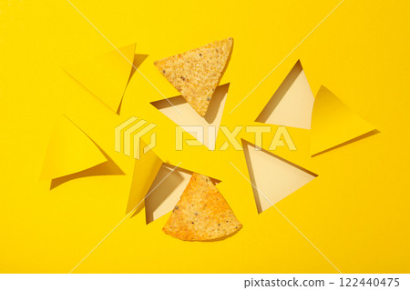 Triangular potato chips on a yellow background Triangular potato chips on a yellow background 122440475