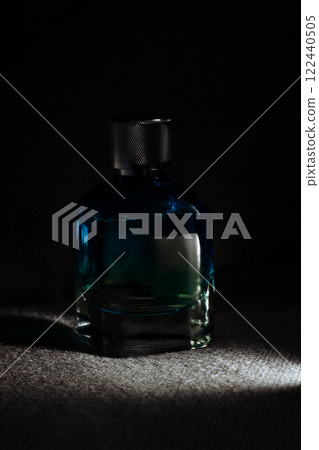 Bottle of perfume with fume on dark background Bottle of perfume with fume on dark background 122440505
