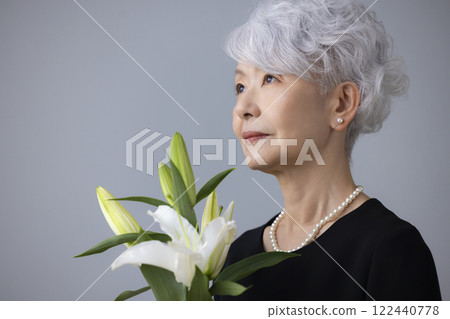 身穿喪服、手持百合花的老婦人 122440778