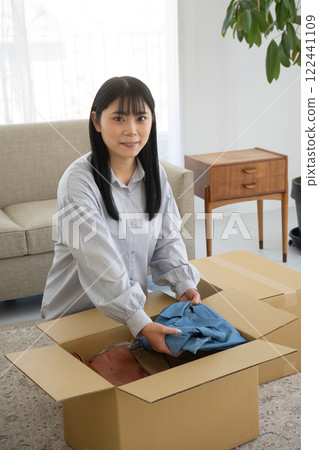 女人把衣服裝進紙箱 122441109