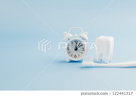 Dentist promoting oral care with a white alarm clock and teeth model Dentist promoting oral care with a white alarm clock and teeth model 122441317
