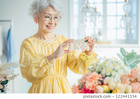 Senior woman taking a photo with a smartphone 122441334