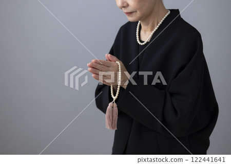 The hands of a senior woman in mourning clothes 122441641