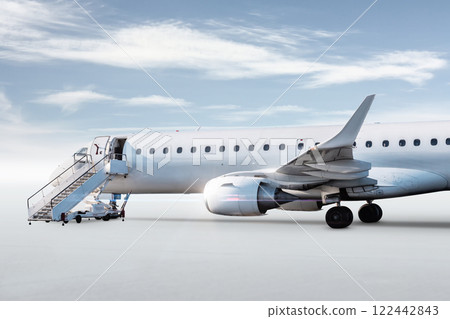 White passenger jet plane with boarding steps isolated on bright background with sky 122442843
