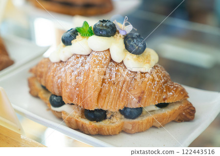 Blueberry Cream Croissant with Powdered Sugar on a White Plate Blueberry Cream Croissant with Powdered Sugar on a White Plate 122443516