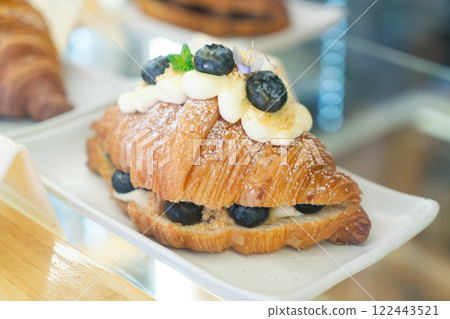 Blueberry Cream Croissant with Powdered Sugar on a White Plate 122443521
