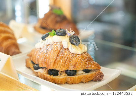 Blueberry Cream Croissant with Powdered Sugar on a White Plate 122443522