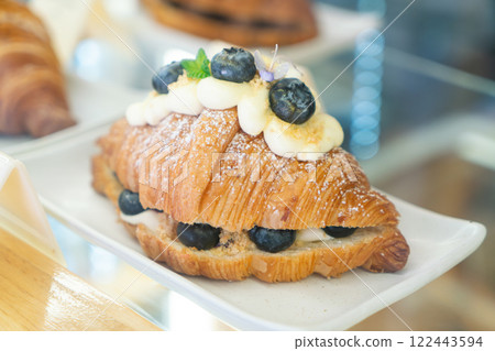Blueberry Cream Croissant with Powdered Sugar on a White Plate 122443594